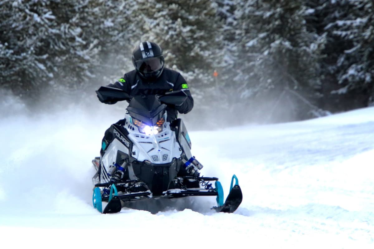 Une personne conduit une motoneige polaris 2025