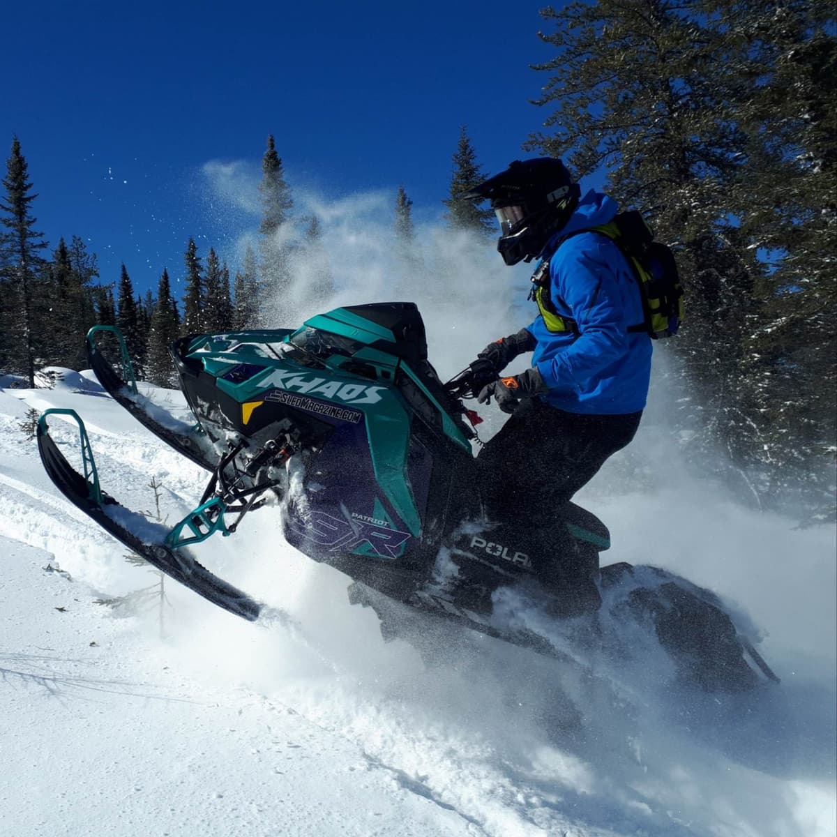 une personne sur sa motoneige RMK Khaos Slash 2024 qui joue dans la neige folle
