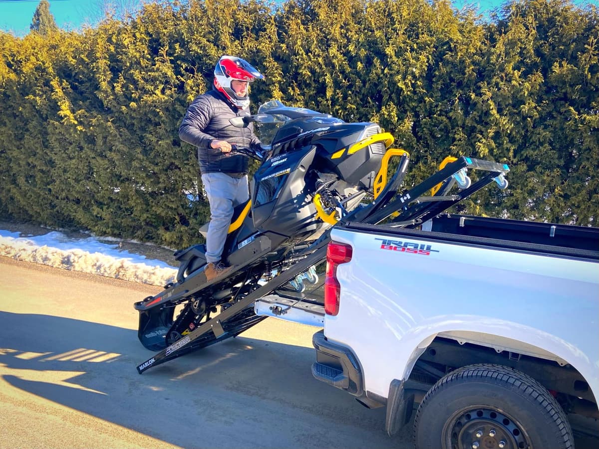 une personne charge une motoneige dans sa camionnette avec la rampe single loader de marlon