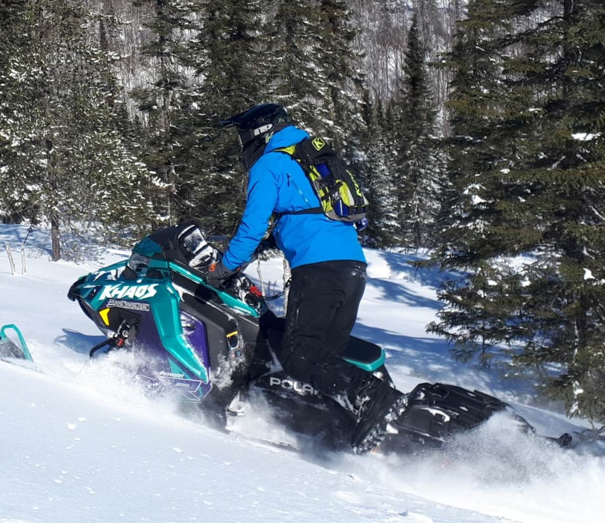 une personne sur sa motoneige rmk khaos slash 2024 dans la neige folle