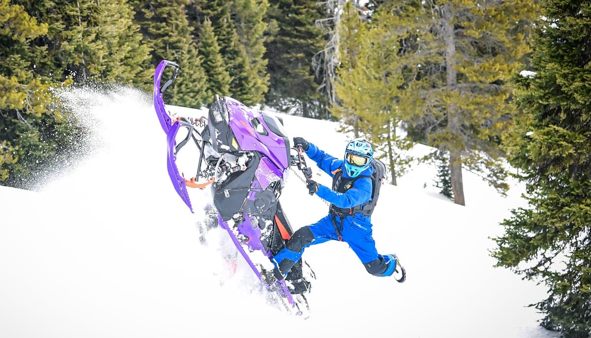 Pilote en bleu effectuant une manœuvre avec le Freeride 2027 Ultraviolet dans la neige.
