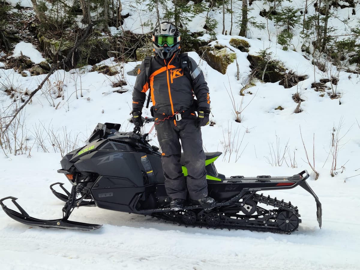 un motoneigiste debout sur la motoneige zr 600 Catalyst 2024