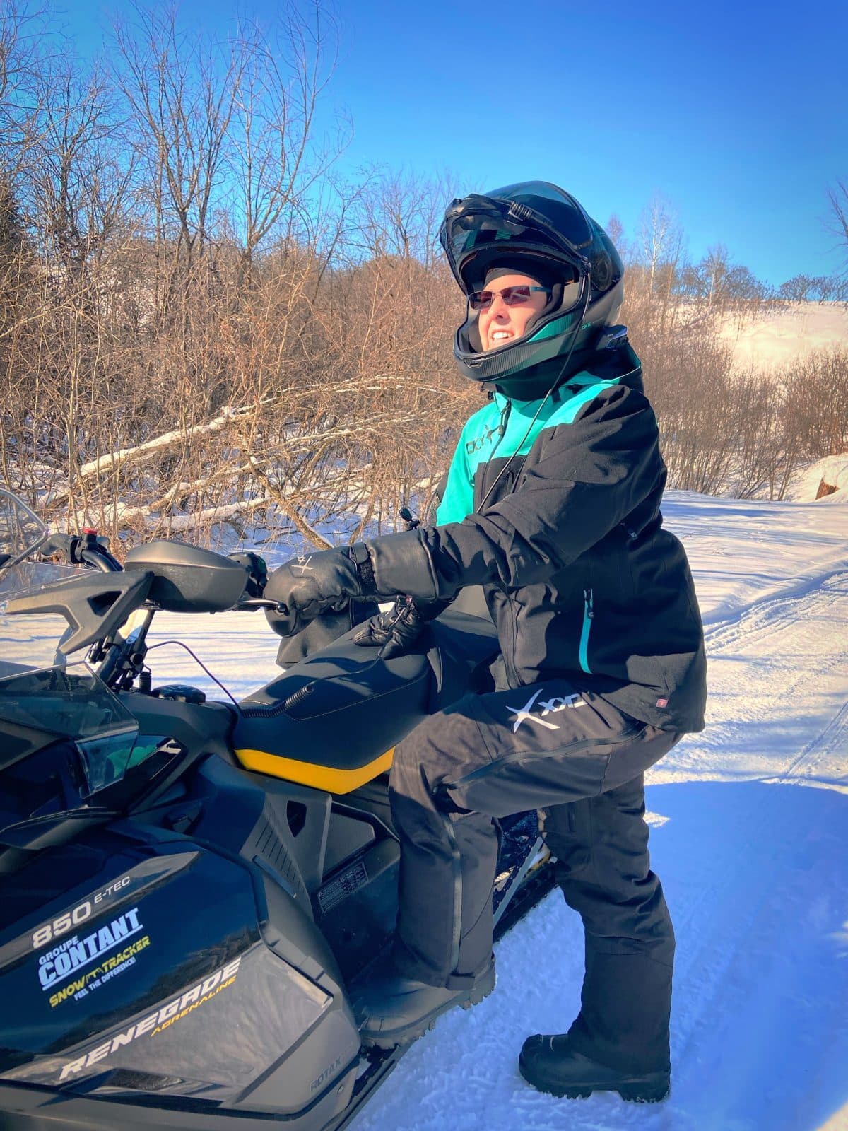 une femme portant l'ensemble ckx alaska qui monte sur sa motoneige
