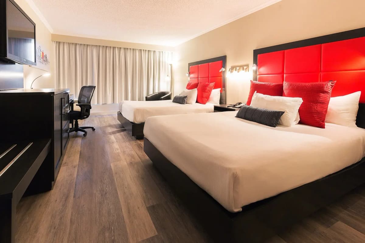 Chambre d’hôtel confortable pour motoneigistes avec deux lits queen.
