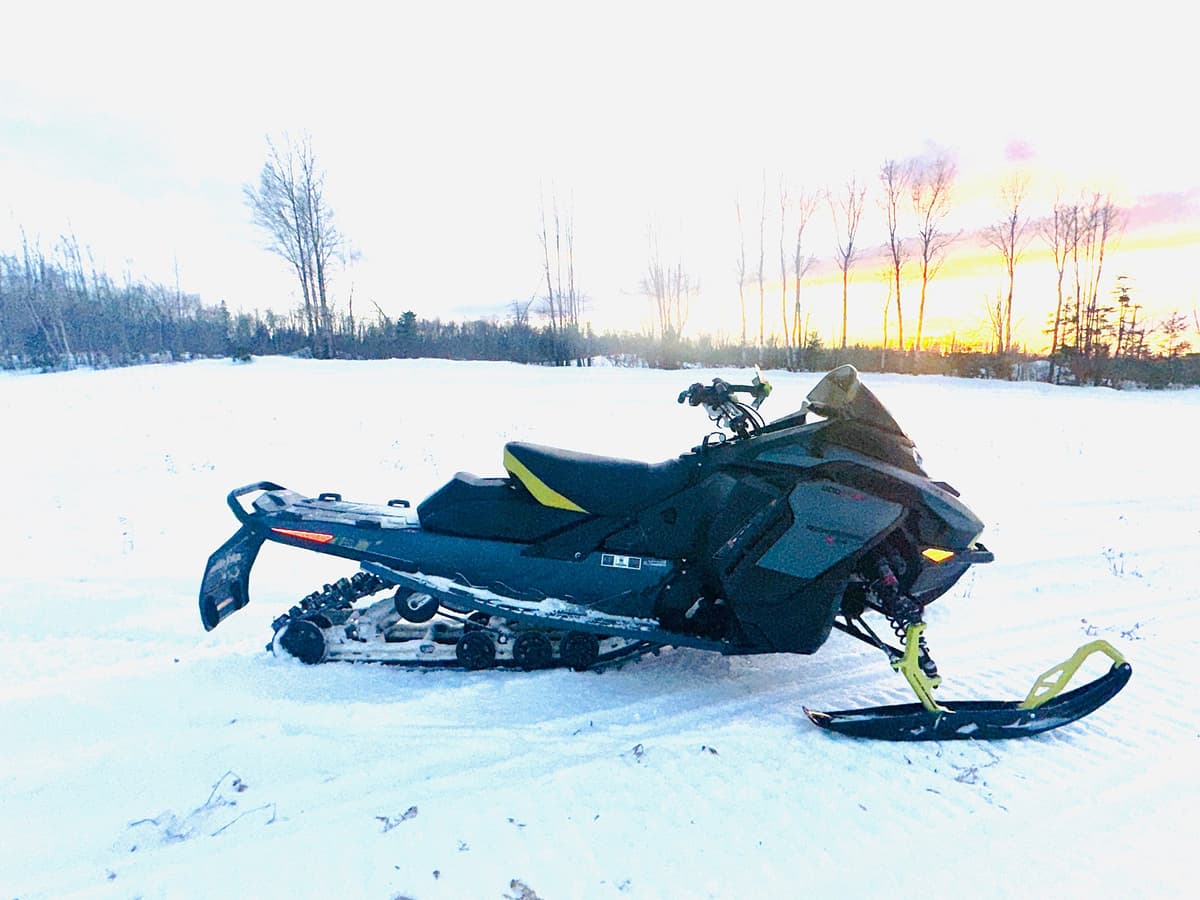 ski-doo renegade x-rs 2026 sur la neige devant un coucher de soleil.