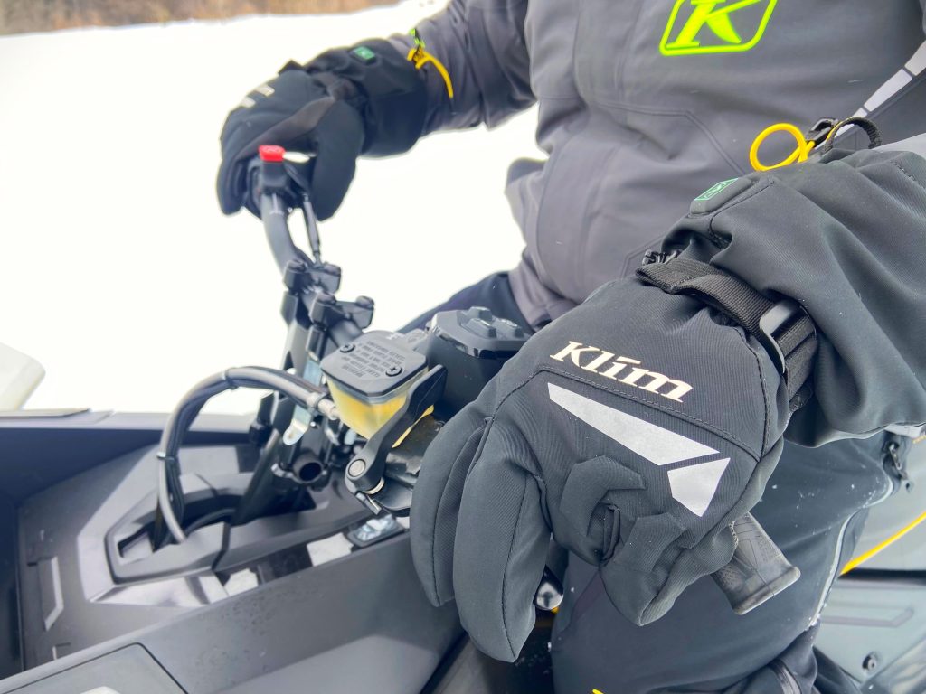 someone wearing resistor htd heating gloves on a snowmobile