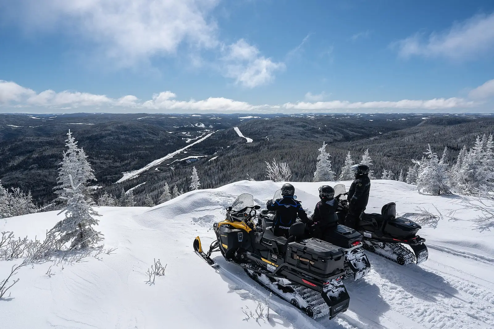 Snowmobiler navigating a well-maintained trail through Monts-Valin’s snowy valleys.