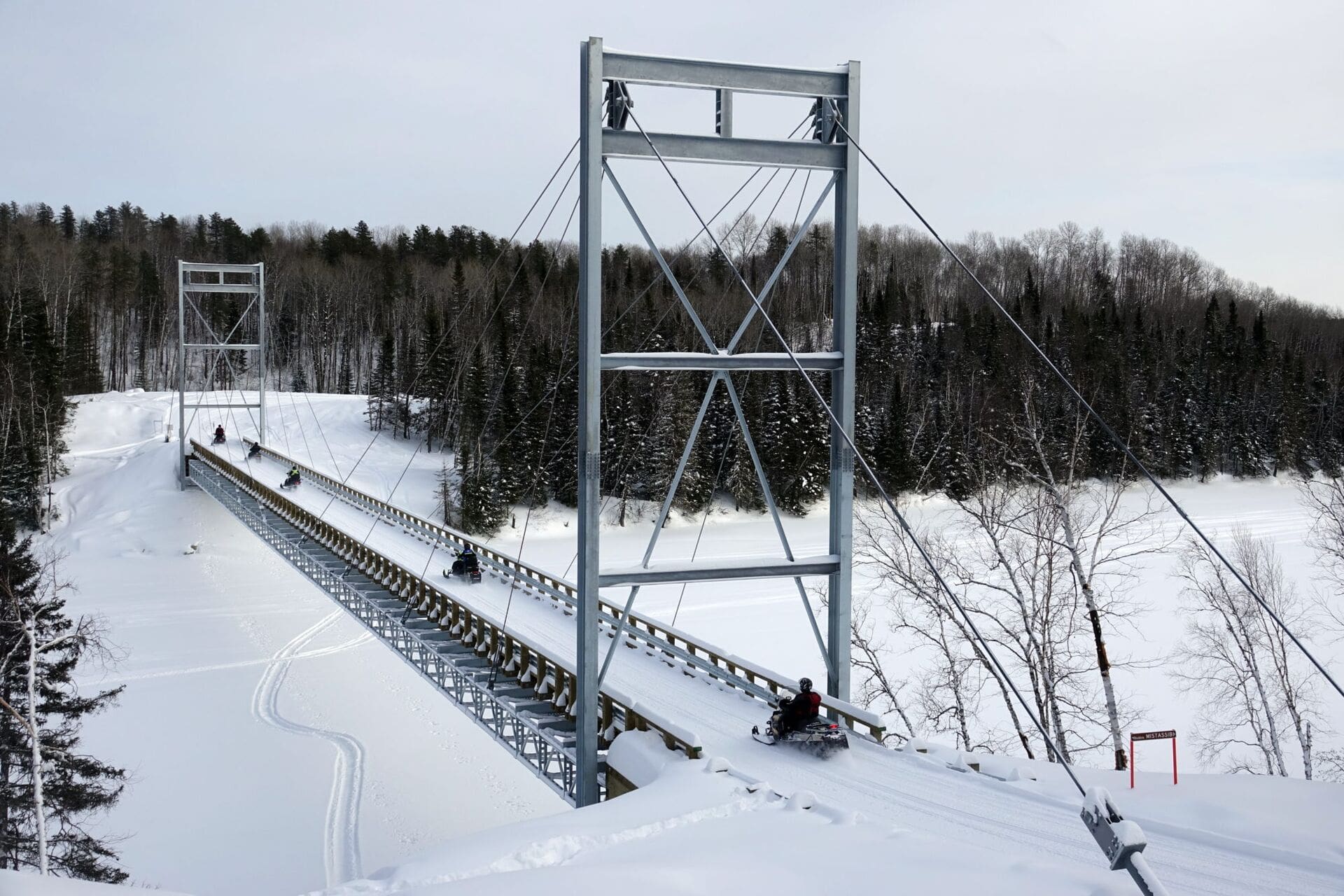 Motoneigistes sur la passerelle traversant la rivière Mistassibi