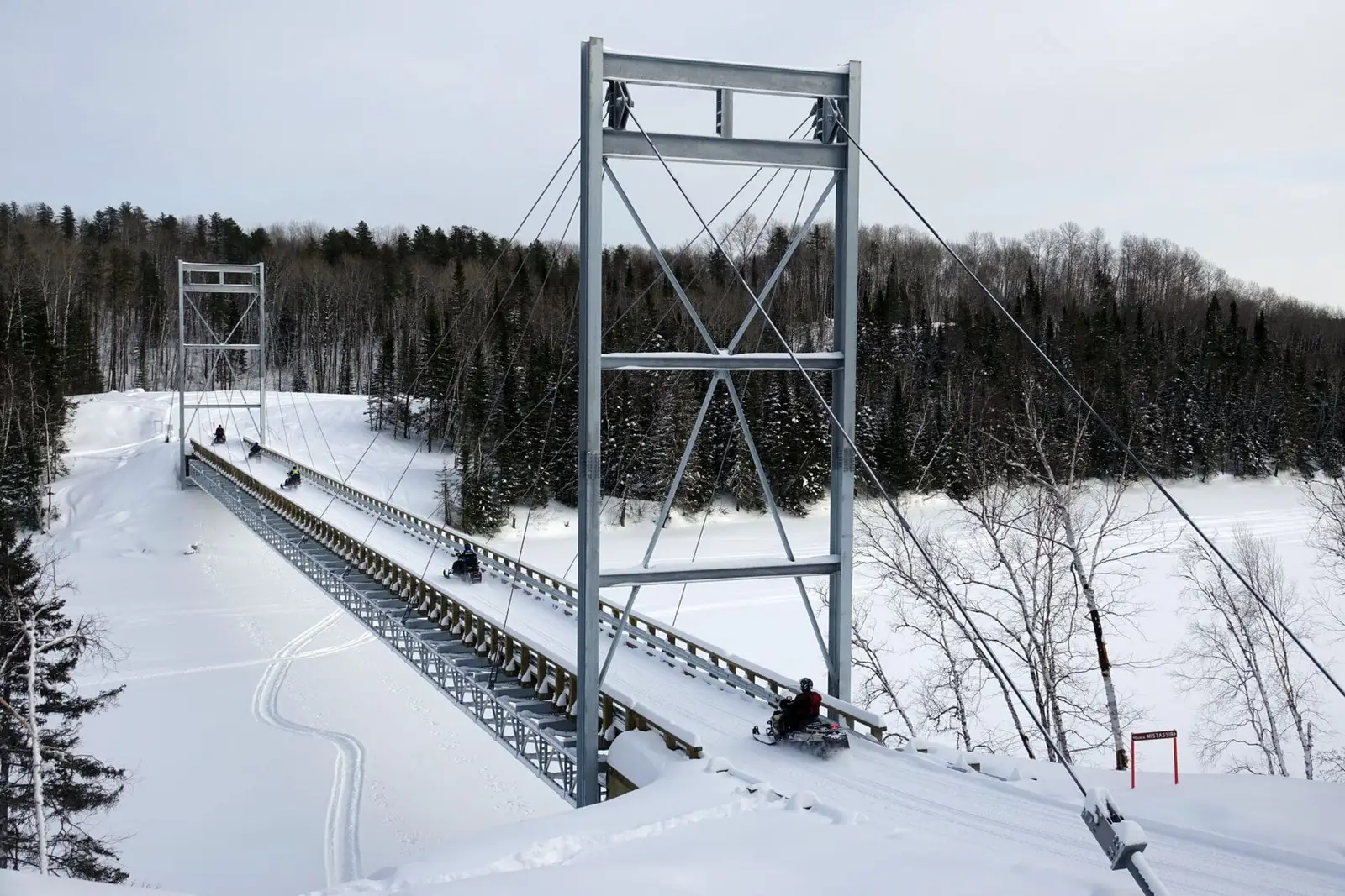 Snowmobilers on the bridge crossing the Mistassibi River | © Yves Ouellet