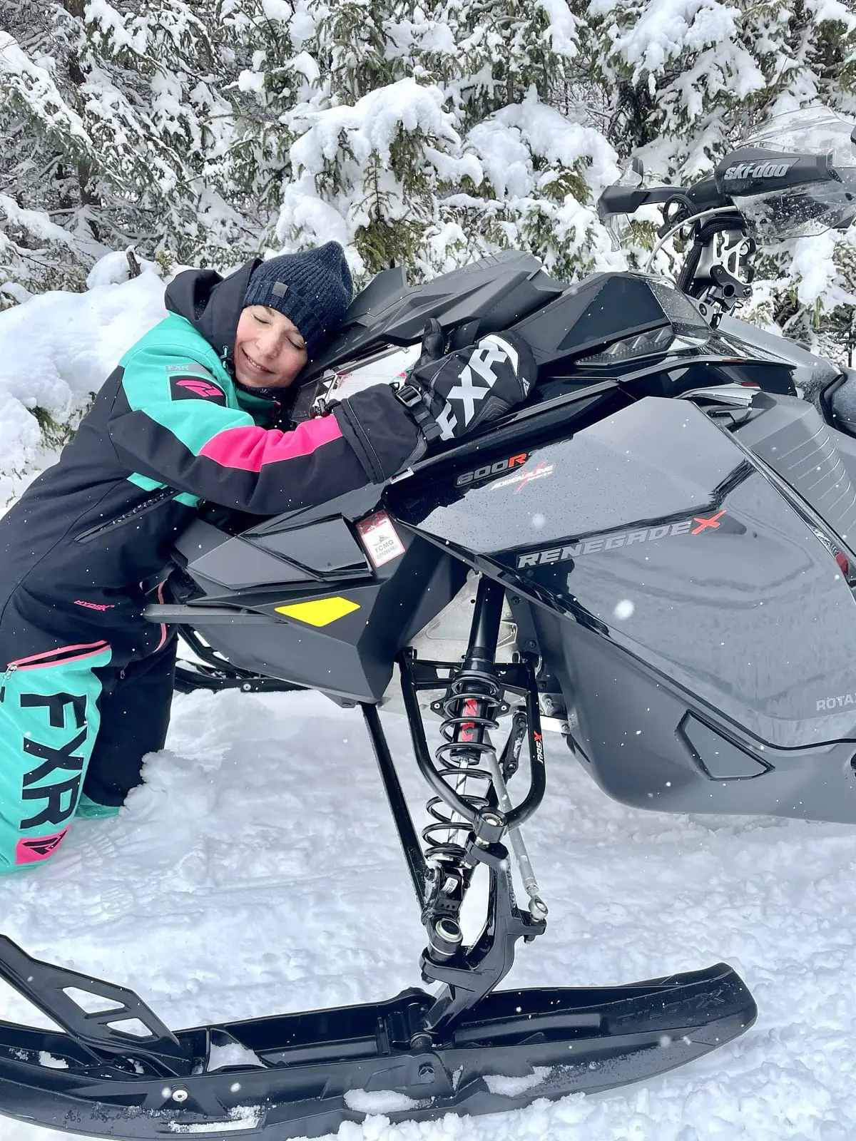 Veronique hugging her Ski-Doo Renegade X 2022 , used snowmobile.