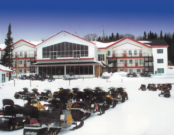 Auberge et motoneiges stationnées en hiver
